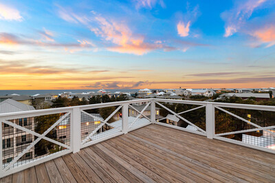 Inspiring sunset views are afforded from the residence's rooftop terraces. There are two (2) terrace levels, an upper terrace (shown here) and a lower terrace, that together allow for 360-degree views of the surrounding town and Gulf of Mexico. OceansideLuxuryAuction.com.