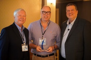 Naylor Gray of Calix (center) accepts the Vendor Marketing Award from Ellis Hill (left) and Charlie Conway of ResearchFirst (right).