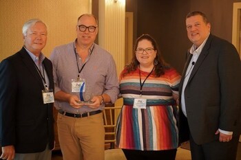 Naylor Gray & Lacey Hawkins-May of Calix (center) accept the Vendor Marketing Award from Ellis Hill (left) and Charlie Conway of ResearchFirst (right).
