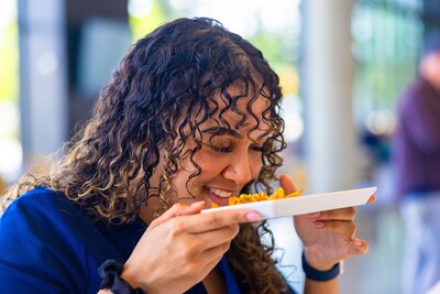 Alaska Airlines Flight Attendant Naomi S.G. takes in the delicious aroma of our new Panang Curry Chicken meal before taking a bite.
