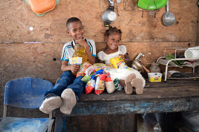 Johaner and his sister with a food kit provided by Compassion International's local church partner.
