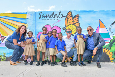 Heidi Clarke, Executive Director of the Sandals Foundation; Adam Stewart, Executive Chairman of Sandals Resorts International and Christopher Elliott, General Manager of Sandals Montego Bay; invite students in Jamaica to the unveiling of Sun Murals created in collaboration with local Caribbean artists in celebration of the Sandals Foundation's 15th anniversary.