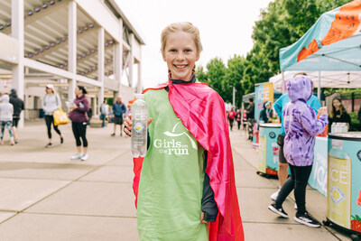 A participant in this year's Girls on the Run Puget Sound spring regional 5K holds up a bottle of Sparkling Ice. Photo by David Jaewon Oh for Girls on the Run.