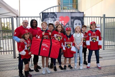 From left to right: Dave Francis, Chief Strategy Officer of CITY; Sabine Delouche, American Heart Association representative; and youth hockey players from the Panthers IceDen.