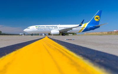 A Ukraine International Airlines plane is parked on the tarmac, aligned with a yellow runway line under a clear blue sky. (CNW Group/Howie, Sacks & Henry LLP)