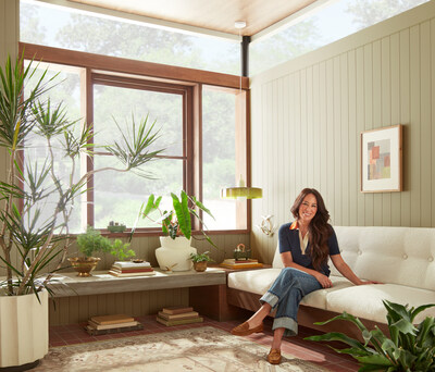 Joanna sits in the plant room, where the color Juniper Tree provides a warm, natural backdrop to complement the lush foliage surrounding her.