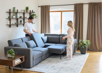 A man and woman set up the sleeper style option of The Neptune Sofa. (CNW Group/Cozey inc.)