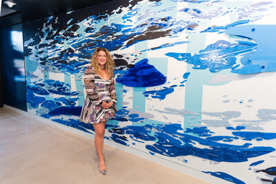 Artist and muralist Katie Murray in front of her mixed-media installation in the Clarus showroom.