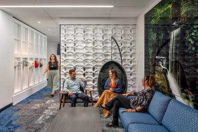 Des collègues discutent de façon décontractée dans un coin de bureau confortable, alliant des éléments de conception naturels au confort. (PRNewsfoto/Excel Dryer)