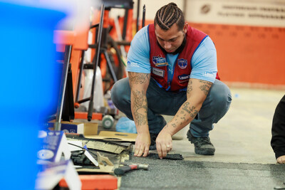 Lowe's associate helps to install a floor at a 2023 Lowe's Hometowns project in Greensboro, North Carolina.