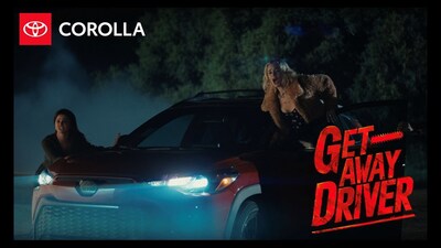 Two of Bach's friends urge him to get into the Toyota Corolla Cross Hybrid Nightshade, as they run away from a guy with a chainsaw in Getaway Driver.