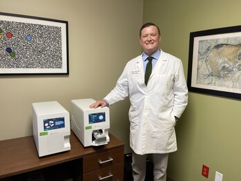 Dr. Jeremy Woods, Valley Children's Precision Medicine Director, with machine that tests for changes in the MT-RNR1 gene