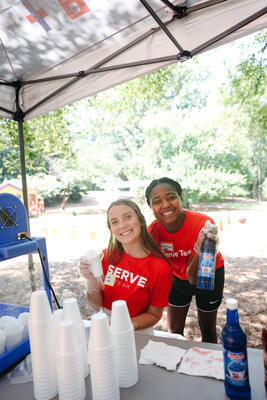 Two Serve Day volunteers serve snow cones at an international picnic where Auburn University students from different nations gathered to build relationships while playing games and cooking out. It was one of more than 1,000 Serve Day projects on July 13.