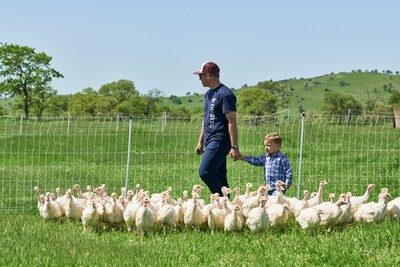 Jason Diestel, fourth-generation farmer at Diestel Family Ranch, walks with his son through Diestel's regenerative turkey field.