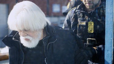 Paul Watson being escorted by Danish police in handcuffs off the M/Y JOHN PAUL DEJORIA as it arrived in Greenland to refuel.