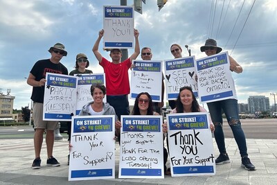 Group of LCBO workers holds up "thank you" picket signs thanking their community and allies for support. (CNW Group/Ontario Public Service Employees Union (OPSEU/SEFPO))