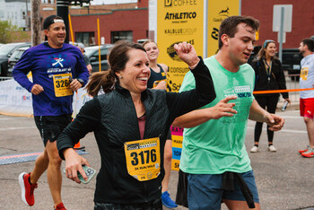 A group of 5k Runner celebrate crossing the finish line at the 2024 Zeigler Kalamazoo Marathon
