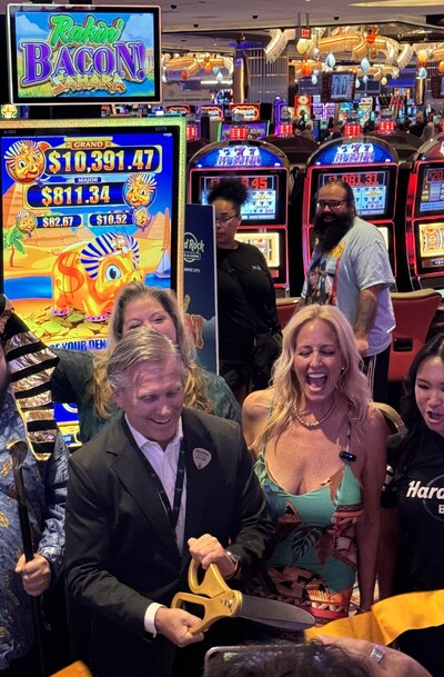 Hardrock, Atlantic City, NJ President George Goldhoff with Lorraine, "Goddess of Slots" during the ribbon cutting, for the rollout of the new Rakin Bacon slot game.