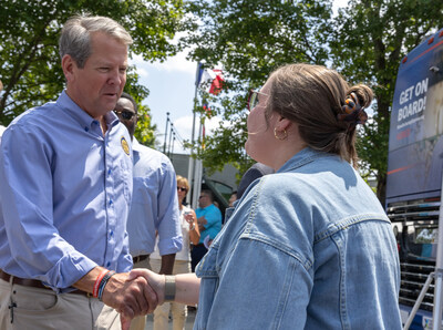 Georgia Governor Brian Kemp (left) greets an AGCO team member at the company’s worldwide headquarters in Duluth, Georgia, at an AEM Manufacturing Express event in August 2024.