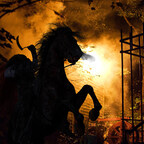 Headless Horsemen on rearing horse in front of fiery inferno at Headless Horseman Hayrides and Haunted Attractions