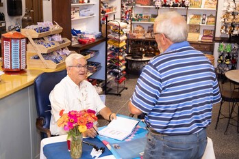 Former Blue Bell CEO Ricky Dickson signs a copy of his book, "One Scoop at a Time," during a signing event held Friday, August 30, 2024, in Miss Anne's Ice Cream Shoppe.