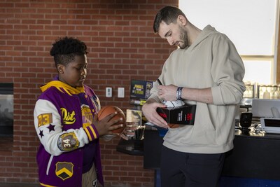 UConn Men's Basketball Player Alex Karaban signing a ball for a Boys & Girls of Clubs of Hartford member.