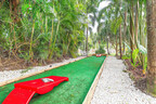 Enjoy a friendly game of cornhole in this shaded, tropical nook surrounded by lush palm trees and natural beauty, perfect for casual outdoor fun.