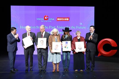 Qu Yingpu (right), publisher and editor-in-chief of China Daily; Hu Wei (left), president and CEO of Bank of China USA, and guest speakers holding their souvenir portraits pose for a photo at the Vision China event in New York on Thursday. FENG YONGBIN / CHINA DAILY (PRNewsfoto/China Daily)