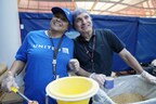 Two United Airlines employees volunteering at Chicago O'Hare International Airport (ORD) to package nutritious meals with Rise Against Hunger.