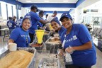 United Airlines employees smile for a photo while packaging meals with nonprofit Rise Against Hunger at Newark Liberty International Airport (EWR).