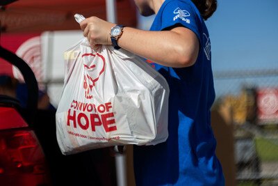 A volunteer with Convoy of Hope delivers a bag of groceries to a survivor of Hurricane Helene in Perry, Florida.
