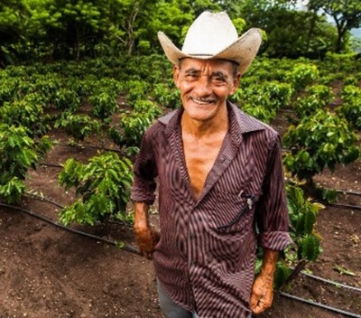 Ubaldo Trochez stands in his irrigated coffee field in Honduras. The EU has passed new deforestation regulations that coffee growers, including small-scale producers like Ubaldo, will need to follow to export their coffee to the EU. Photo by USAID via Flickr, licensed under CC BY-NC-ND 2.0.