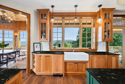 The kitchen is just off the main living areas, and features beautiful wood finishes in the Adirondack style. The dining area (left) and walk-out access to the home’s sprawling, outdoor deck (right) is conveniently adjacent. NewYorkLuxuryAuction.com.