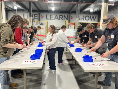 Honda associates at Indiana Auto Plant show students how to work together assembling a model car.