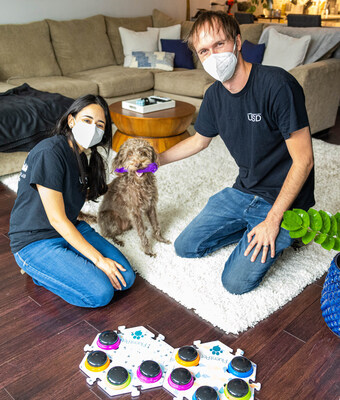 Purina announced a new partnership with the University of California San Diego Comparative Cognition Lab focused on understanding augmentative interspecies communication (AIC) devices. Researchers Amalia Bastos and Patrick Wood pose with one of the canine study subjects in the dog's home. Photo courtesy of the Comparative Cognition Lab at UC San Diego.