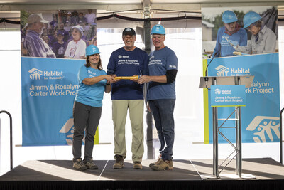 ST. PAUL, MINNESOTA, USA (10/04/2024) — Austin Habitat for Humanity CEO Michele Anderson (left) joins Habitat for Humanity International CEO Jonathan Reckford and Twin Cities Habitat for Humanity President and CEO Chris Coleman for the ceremonial passing of the hammer. Austin Habitat will host the 2025 Jimmy & Rosalynn Carter Work Project. © Habitat for Humanity International/Raymond McCrea Jones.