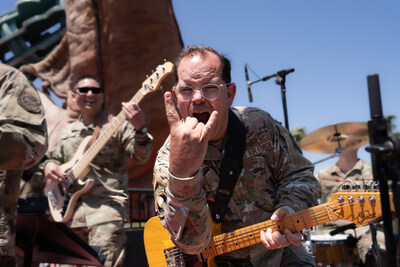 A guitarist in Mobility, the Air Force Band of the Golden West's rock ensemble, interacts with the audience during a live outdoor performance.