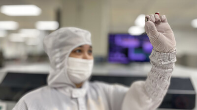 TI employee examines a finished GaN chip. GaN chips enable energy-efficient, reliable and power-dense end products.