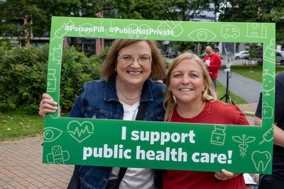 Unifor National President Lana Payne and Atlantic Regional Director Jennifer Murray stand together inside a picture frame that reads "I support public health care" at a rally outside the Premiers' Meeting in Halifax on July 16, 2024. (CNW Group/Unifor)