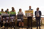 Activists hold signs at a press conference while legal experts discuss the findings of hidden camera footage placed in Denver's slaughterhouse.