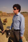 Dr. Mickey Pardo, a biologist specializing in animal behavior, pets a sheep while speaking to journalists about humane handling violations at Superior Farms' Denver slaughterhouse.