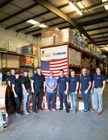 MasterPlan Construction Inc. team with Candice Cornish from Rebuilding Together Tampa Bay at their warehouse.