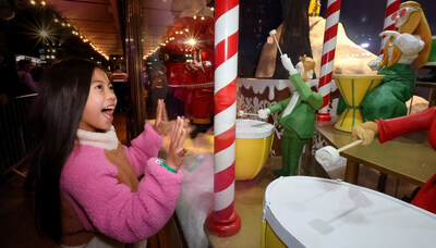 A girl from the crowd experiencing the Fenwick Christmas Windows - Twelve Days of Christmas by Chris Riddell