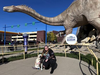 Even the local pups put on bracelets to pose with the dinosaur before Taylor Swift's concert in Indianapolis.