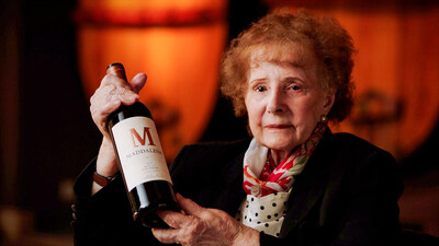 Maddalena Riboli Holding a bottle of Maddalena Merlot.