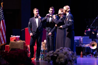 Four vocalists from the Air Force Band of the Golden West harmonize while singing holiday carols with the concert band.