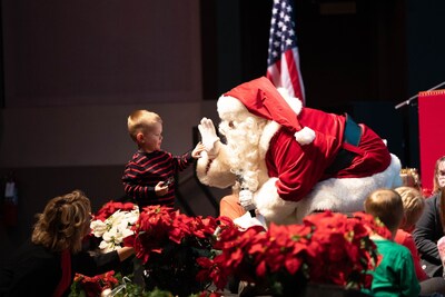 A young audience member gets the chance to meet special guest Santa Claus during the Air Force Band of the Golden West Concert Band's holiday program.