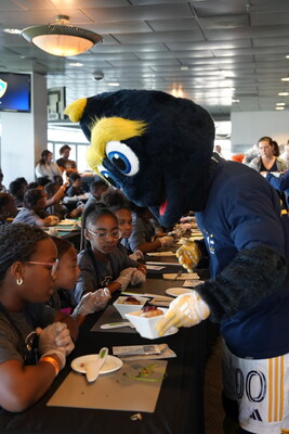 Cozmo, LA Galaxy's mascot, assists Los Angeles-area students in showcasing their Thanksgiving culinary creations at the third annual Thanksgiving Cookoff, hosted by Herbalife, LA Galaxy, and the Garden School Foundation.