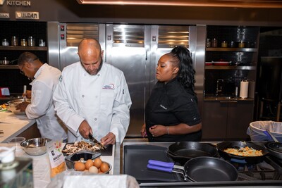 Chef Joseph DeJarnette chopping mushrooms while being trained by Chef Kisha. Participants were able to improve upon their cooking skills, like knife cuts, during this training.