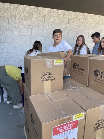 A student stacks donations, preparing them for delivery to Caterina's Club.